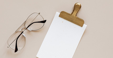 Leeres weißes Papier mit einem Brillengestell daneben