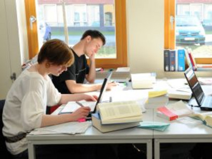 Studierende sitzen an einem Tisch in der Bibliothek und lernen