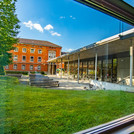 Benches and tables of the refectory, behind it the refectory and an adjacent house