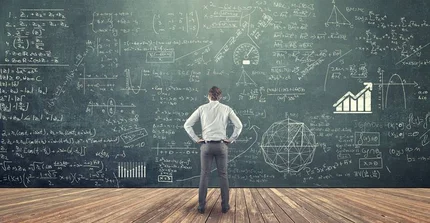 Ein Postdoc steht vor einer vollbeschriebenen Tafel