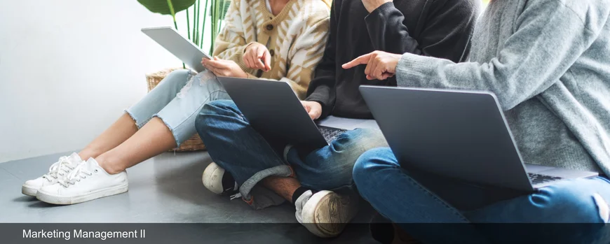 Drei Menschen sitzen mit Laptops auf dem Boden.