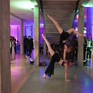Zwei Akrobatinnen in einem Foyer mit bunten Lichtern.