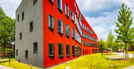 Ein rotes Gebäude, das eine wellenförmig geschwungene Fassade hat