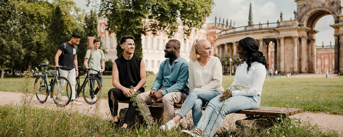Studierende auf dem Campus am Neuen Palais - Link zu den Infos zum Studienstart