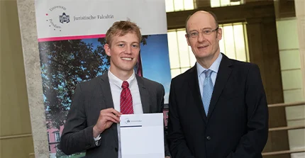 Auf dem Bild steht Oskar Wernitz neben Prof. Dr. Sonnentag und hält stolz seine Auszeichnung in die Kamera. Im Juni 2024 wurde der Absolvent feierlich mit dem Wolf-Rüdiger-Bub-Preis geehrt.