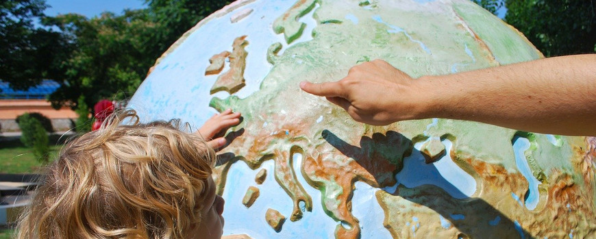 Kind bekommt Weltkarte erklärt