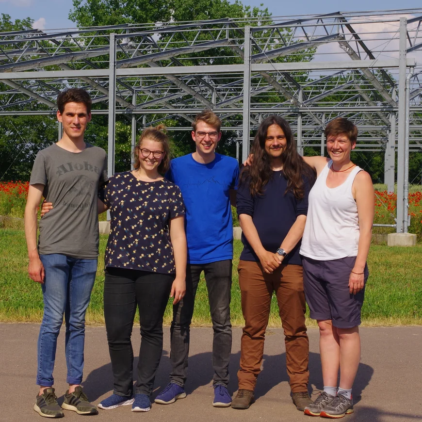 a group of people standing in front of a framework