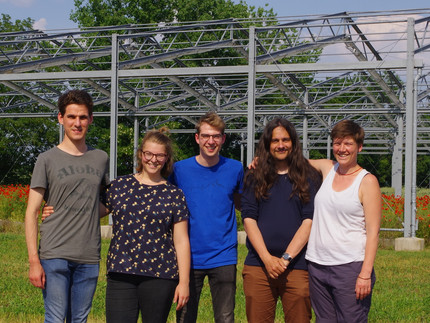 a group of people standing in front of a framework