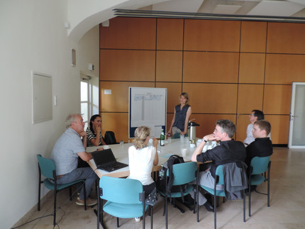 Personen am Tisch in Besprechung und White Board