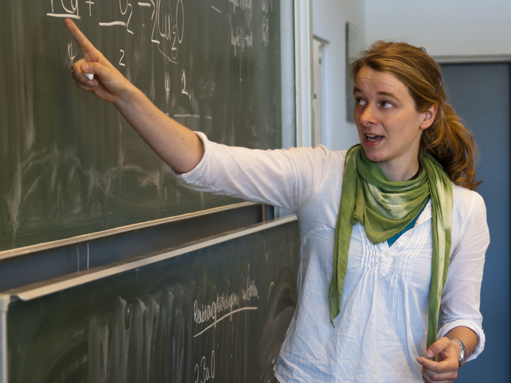 Lehrerin zeigt auf Tafel