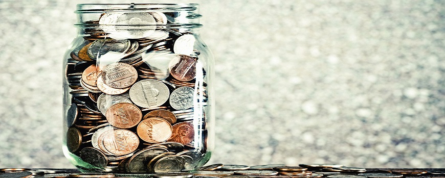 a glass filled to brimming with coins