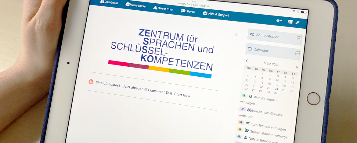 Hand mit iPad in der Hand, Moodle auf dem Bildschirm zu sehen - 